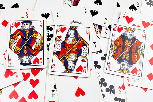 Stack of playing cards with on the top, the jack, queen, and king of heart.