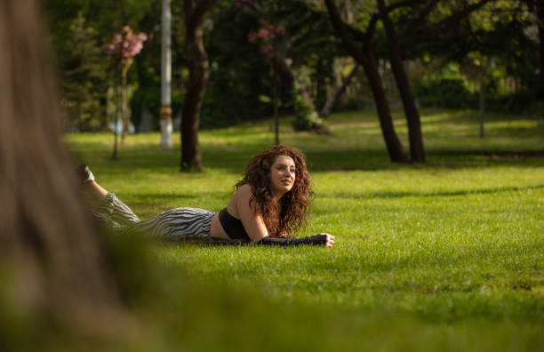 istock Young brunette woman having fun on the grass in springtime. 1486536715