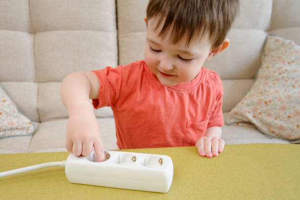 istock Little baby playing with electrical cords at home is a dangerous activity that could result in electric shock or injury. Kid aged about two years (one year ten months) 1486538937