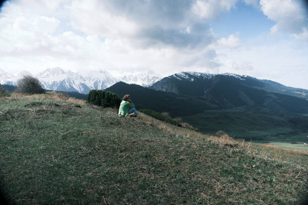Female backpacker is sitting on the rock while hiking at mountains