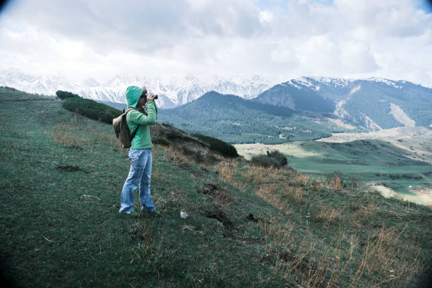 istock Female backpacker is looking at binocular at red rocks and remote mountains 1486541558