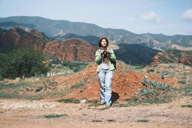 istock Female backpacker is looking at binocular at red rocks and remote mountains 1486541796