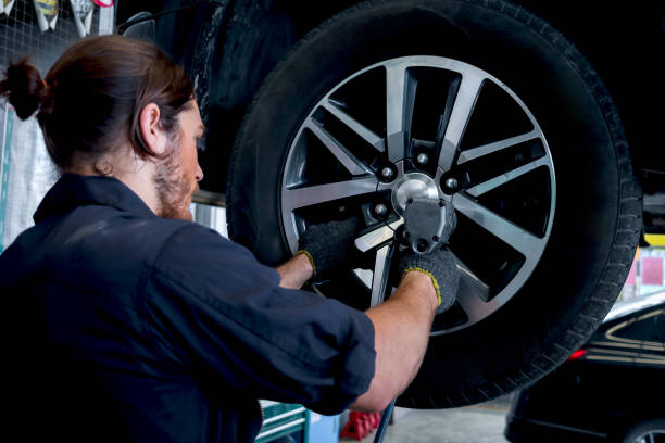 istock Auto mechanic handsome worker man checking wheel tires at garage, car service technician checking and repairing customer car at automobile service center, vehicle repair car service shop. 1486542212