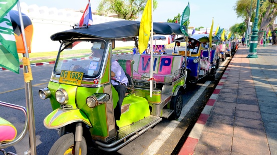 April-29-2023, Bangkok, Thailand :  Front view of Thai tuk-tuk vehicles parking in front of the Grand Palace waiting for tourists.