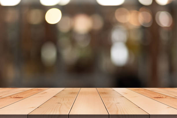 istock Empty wooden table top with lights bokeh on blur restaurant background. 1486557391