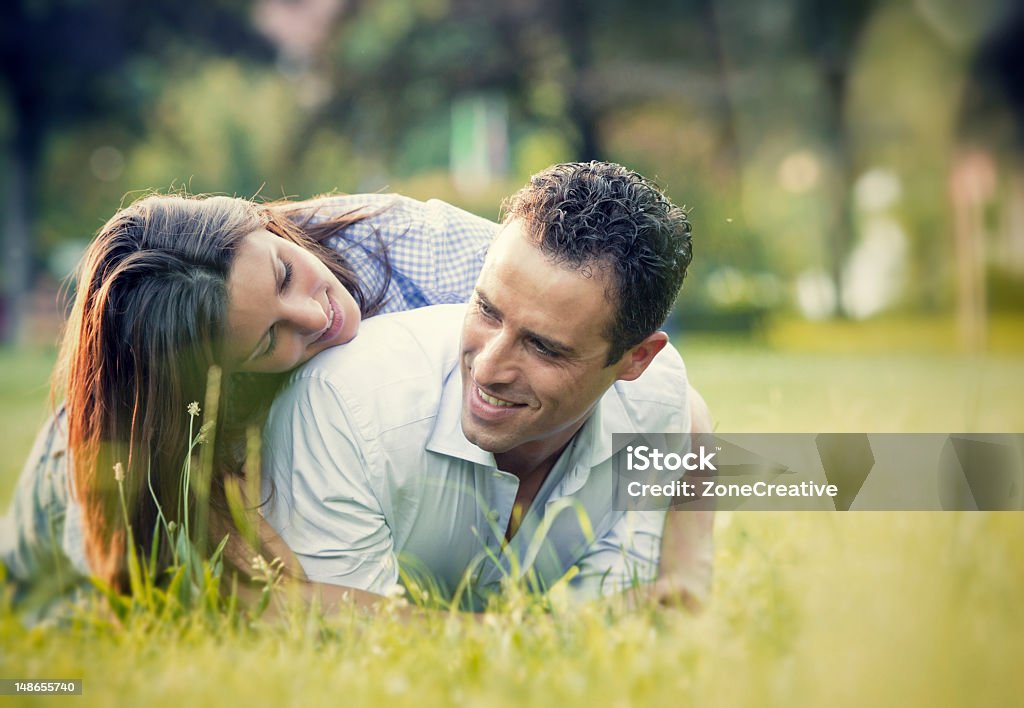 Giovane Coppia che si diverte nel parco - Foto stock royalty-free di Abbigliamento casual