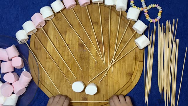 Preschool kids cooking activity. Putting marshmallows on the sticks. Timelapse