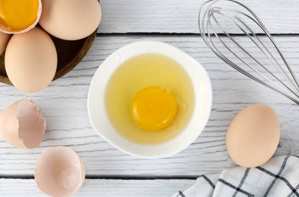 istock Cooking baking ingredients eggs, whisk and kitchen textiles on a white background. Pie or cake recipe. Top view. Copy space. 1486564000