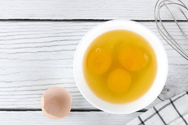 istock Cooking baking ingredients eggs, whisk and kitchen textiles on a white background. Pie or cake recipe. Top view. 1486564002