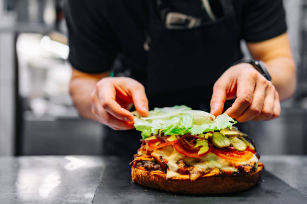 istock chef hand cooking big large cheese burger on restaurant kitchen. step by step 1486565458