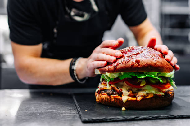 istock chef hand cooking big large cheese burger on restaurant kitchen. step by step 1486565465