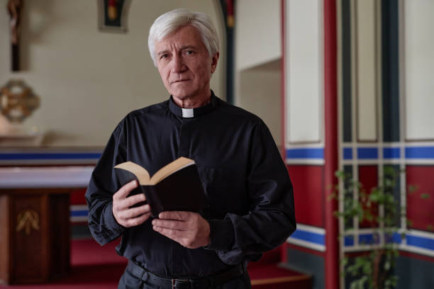 istock Senior priest with BIble in church 1486567423