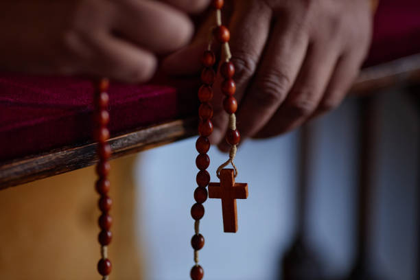 istock Woman praying with rosary beads 1486567435