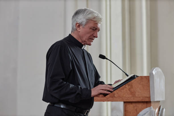 istock Priest reading sermon in microphone in church 1486567439