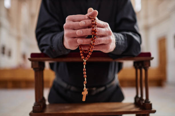 istock Man with rosary beads praying in church 1486567449