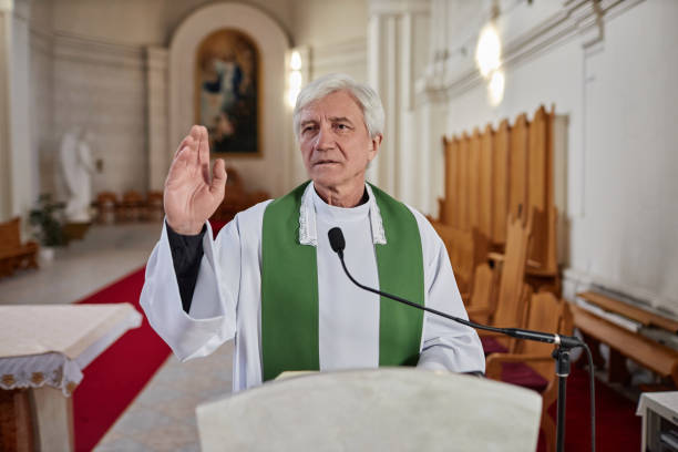 istock Priest reading Bible in microphone in church 1486567461