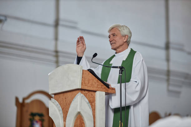 istock Priest reading sermon and blessing people 1486567464