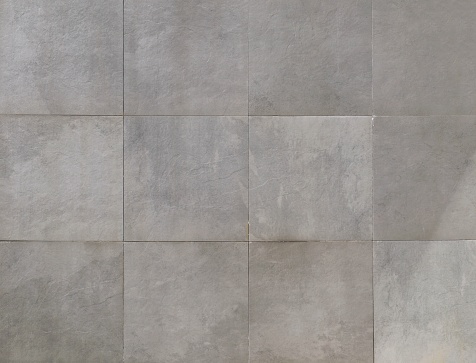 Elegant large gray square stone tiles. Bckground and texture.