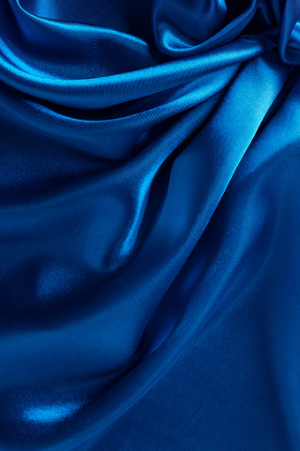 Blue color atlas material background, silk abstract textile surface, drapery cloth