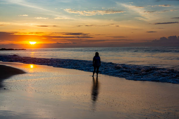 istock Woman walking on the beach sunrise 1486576209