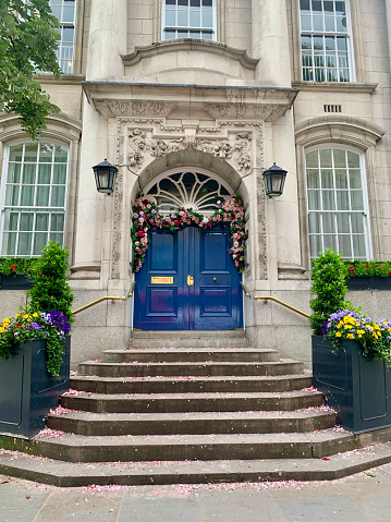 Town hall building in Chelsea, UK.  Bright blue door decorated with flowers for a wedding.  Stone steps and intricate doorway.
