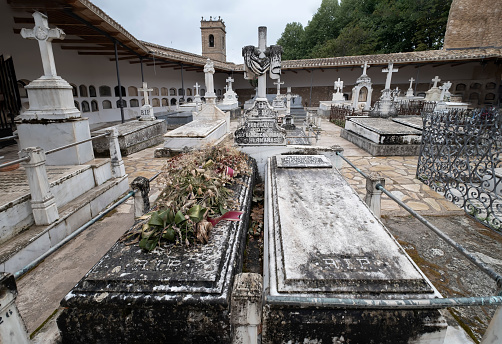 ancient tombs with dried flowers and wreaths in the cemetery of Brihuega, inside the Castle of Peña Bermeja, Brihuega, Guadalajara, Spain