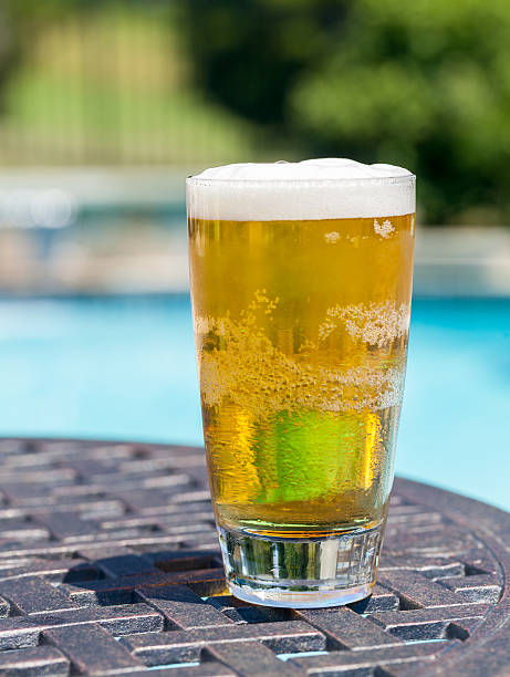 istock Glass of beer on table by poolside 148658095