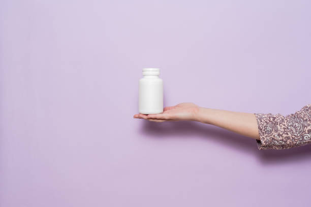 istock White plastic bottle in female hand. Packaging for pills, capsules or supplements. 1486582735