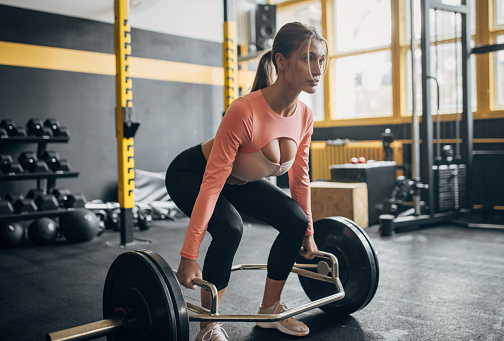 One woman, fit female training with weights in gym.