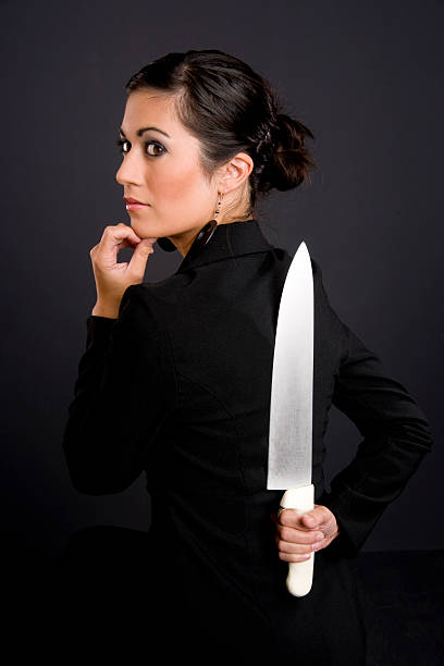 istock Hiding the Blade Woman Conceals Kitchen Knife Behind Her Back 148658657