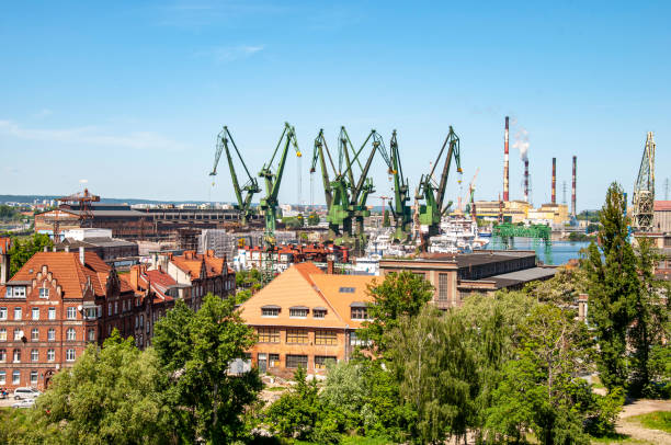 istock Port with ships, ferries, cranes. Cranes for loading, unloading various cargoes and containers. Port of Gdansk. Barges in docks of the Baltic sea. Factories in the background. 1486586670