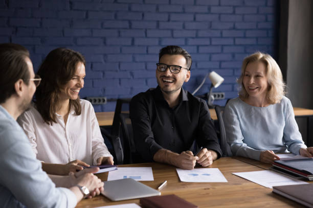 istock Happy motivated creative business team sitting at meeting table 1486590104