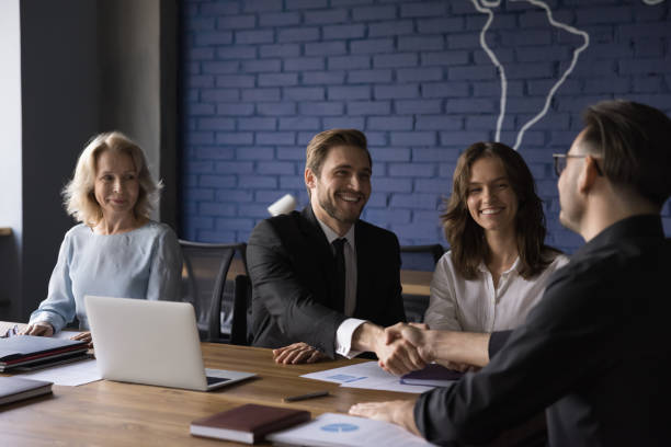 istock Happy confident business partner men shaking hands over meeting table 1486590222