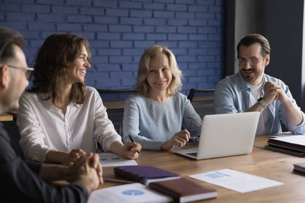 istock Positive senior mentor woman training employees, interns 1486590926