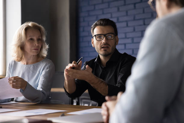 istock Serious engaged business startup leader man speaking to colleagues 1486590934