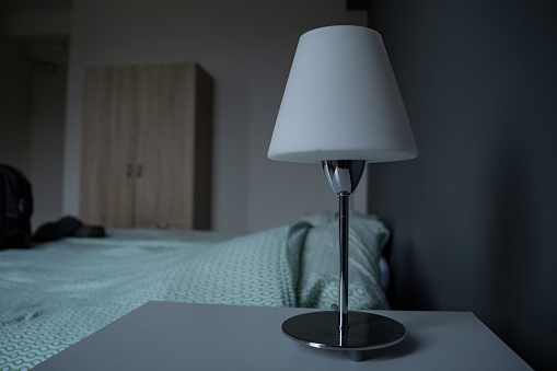 Bedside table with lamp. Hotel room, apartment.