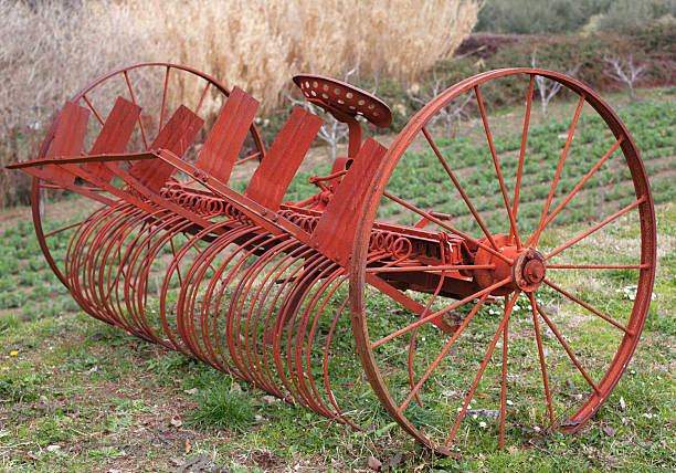 An old red vintage hay rake reminds us of how farming was done years ago.