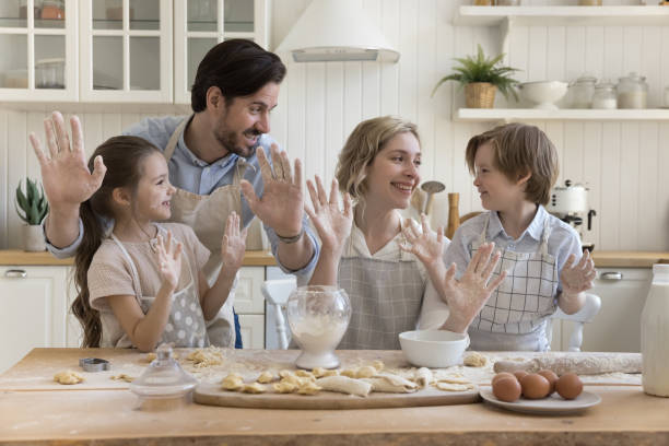 istock Joyful parents and two happy kids in aprons baking together 1486602428