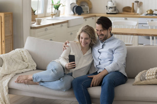 istock Joyful young dating couple hugging on home sofa 1486606894