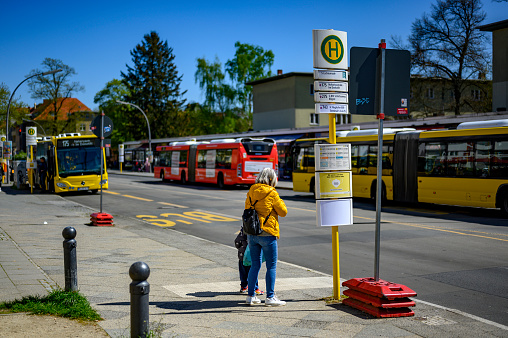 Berlin, Germany - April 30, 2023: Street scene at a bus stop in a small shopping street in Lichtenrade on the outskirts of Berlin, Germany.