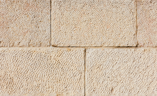 the texture of the old stone Jerusalem wall in beige color, natural stone, the photo can be used as a background