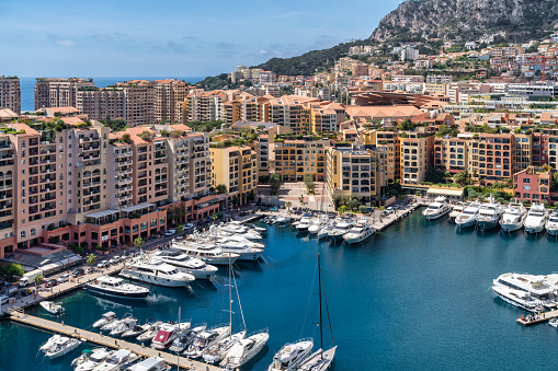 April 30, 2023: This photo shows the glamorous and luxurious principality of Monaco, nestled on the stunning French Riviera. The image captures a panoramic view of the cityscape, featuring the towering hillside, opulent architecture, and the Mediterranean Sea. The photo is also adorned with the yachts moored in the harbor.