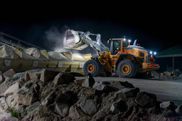 istock Heavy construction and mining machinery unloading gravel into silos on the night shift. 1486623830