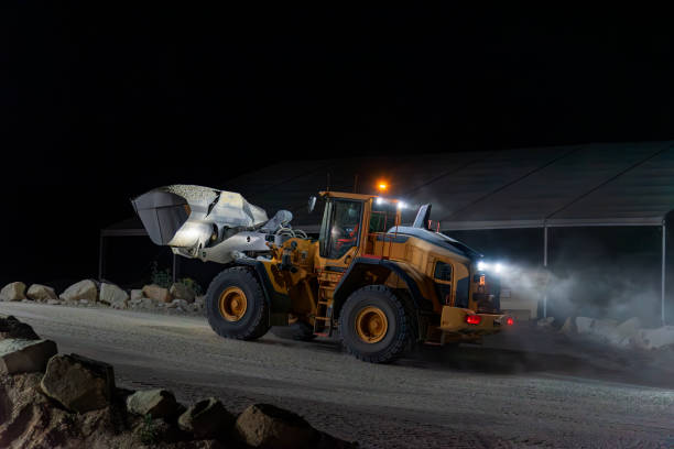 istock Heavy construction and mining machinery with a bucket full of sand, working the night shift. 1486623853