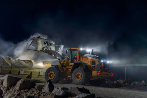 istock Heavy construction and mining machinery unloading gravel into silos on the night shift. 1486623874