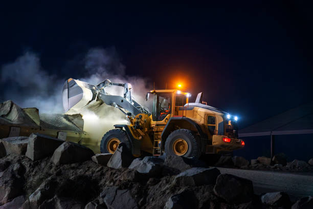 istock Heavy construction and mining machinery unloading gravel into silos on the night shift. 1486623884