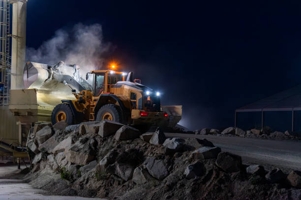 istock Heavy construction and mining machinery unloading gravel into silos on the night shift. 1486623888