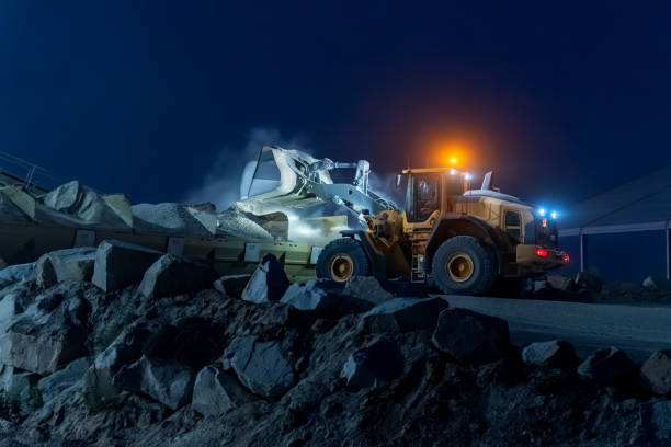 istock Heavy construction and mining machinery unloading gravel into silos on the night shift. 1486623895