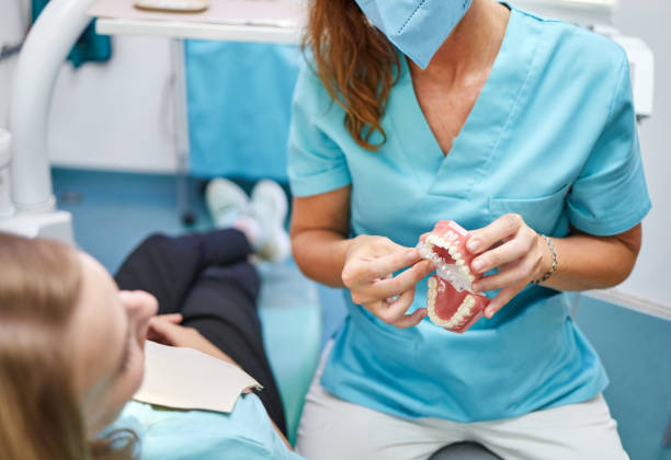 istock Female orthodontist demonstrating retainer and denture mockup 1486625100