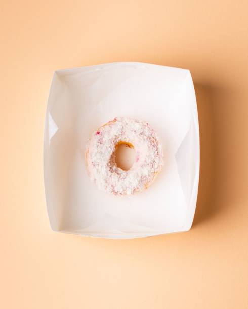 istock Image of a white box containing single donuts on a pink background 1486641604